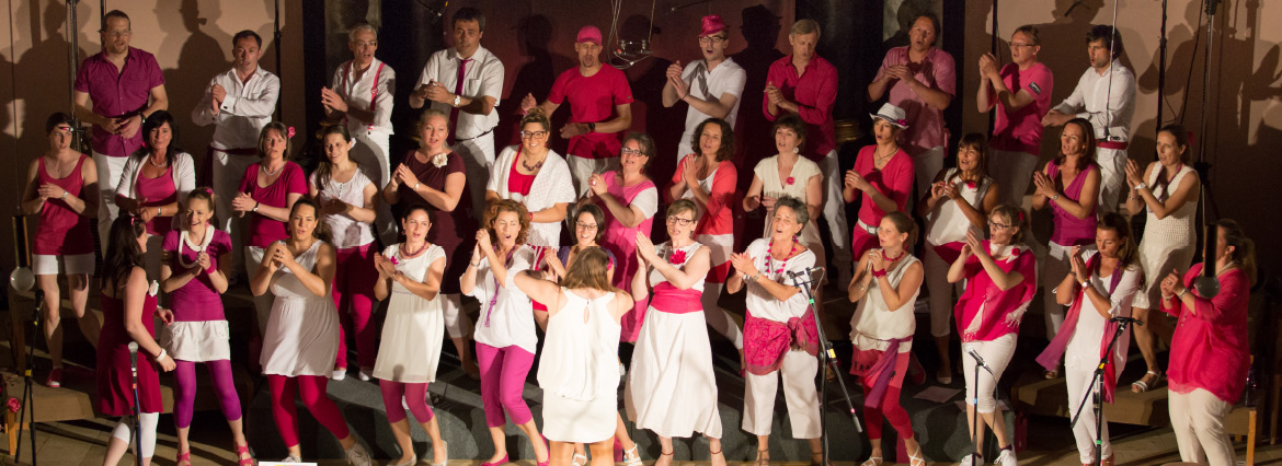 Der Graz Gospel Chor glänzt auf der Bühne mit seinen Mitgliedern in aufeinander abgestimmten weißen und rosa Outfits.